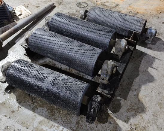 Quatre tambours garnis de caoutchouc à motif losangé posés sur un châssis